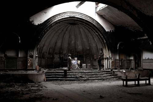 Fighters from the Nineveh Plain Protection Units pray in a destroyed church in the town of Bakhdida,