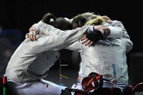 [ID: three wheelchair sabre fencers in a huddle.]Fencing at Montreal 2018!