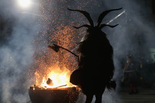 blue-eyed-devil-88:  A member of the Haiminger Krampusgruppe dressed as Krampus hits a fire to release sparks on the town square during their annual Krampusnacht in Tyrol, on December 1, 2013. 