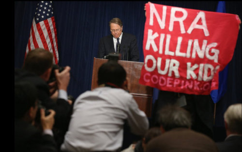 inothernews:NRA, GTFO   A demonstrator held up a banner as Wayne LaPierre, executive vice president 