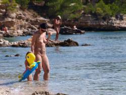 mixedgendernudity:  Smoothly shaved nudist mom with her family at the nude beach.
