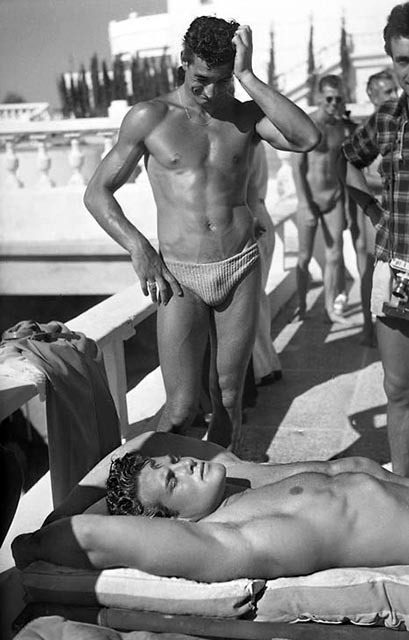 Steve Reeves attracts admiring glances on the beach at Cannes, 1948; photo by Serge de Sazo.