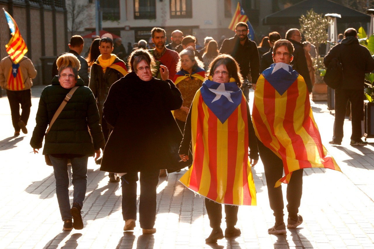 CARETAS. Carles Puigdemont ante el Palau de la Generalitat durante la marcha en la que miles de personas se han reunido en las inmediaciones del Parlament, a la hora en la que debía comenzar el pleno de la sesión de investidura, finalmente aplazado...