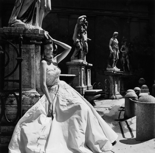 Dorian Leigh, with sculpture, models an evening dress for Giovannelli-Sciarra, Italy, 1952. Harper’s