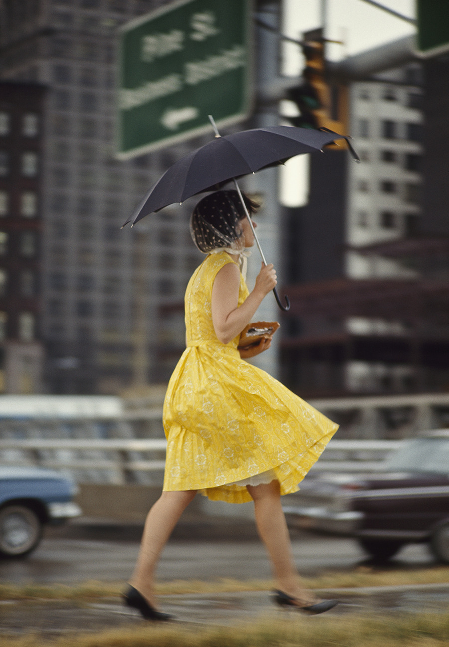 natgeofound:  A woman in a yellow dress uses an umbrella to keep dry in Saint Louis,