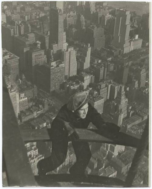 A labourer hangs on a steel beam while working on the Empire State Building (New York City, 1931).