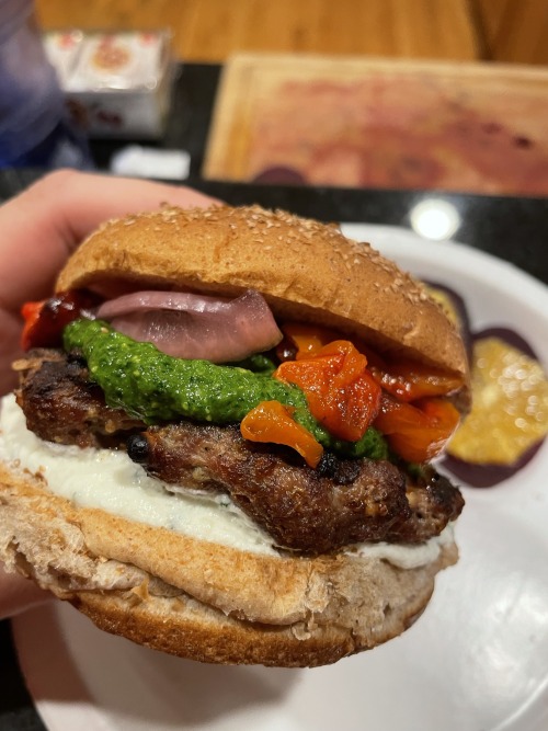 Lamb burger with whipped goat cheese, arugula-spinach pesto, grilled red bell pepper and pickled red