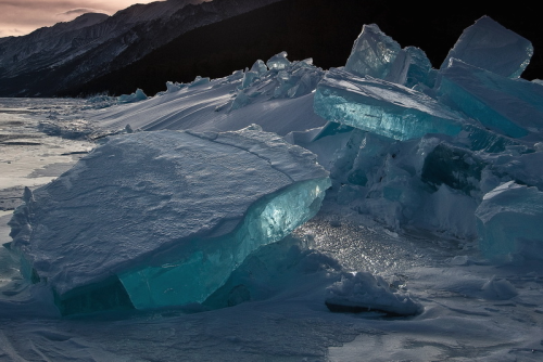 nubbsgalore:  russia’s lake baikal, the world’s oldest, largest and deepest freshwater lake, freezes over for half the year, creating the clear, turquoise ice seen in these photos by (click pic) alexey kharitonov, alexey trofimov, santorifoto, valery