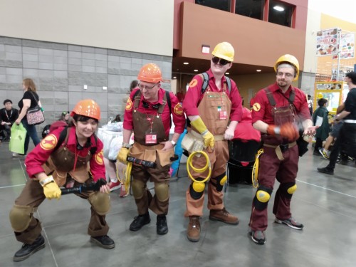 Four engineers all standing together in a pose, similar to the erecting a dispenser pose.