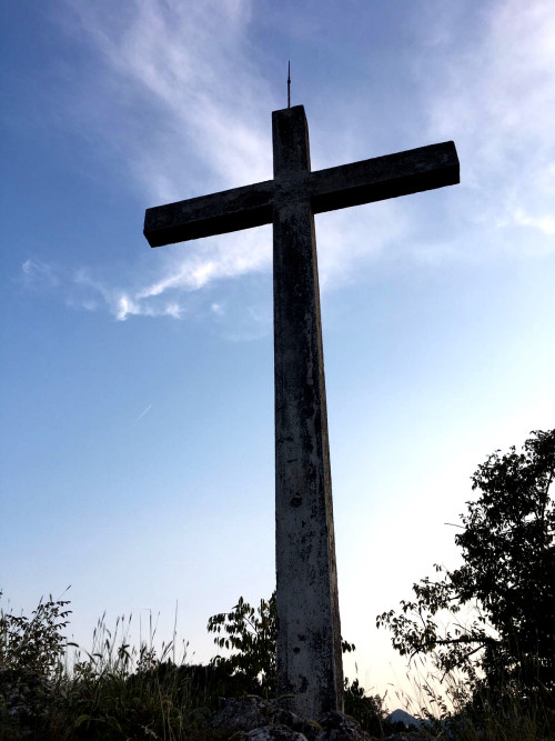 A cross on the top of an Italian Pre-Alps hill.