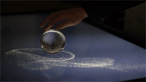 itscolossal:  Watch: Kinetic Sand: A Magical Interactive Glass Sphere Installation [video]