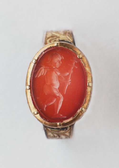 gemma-antiqua:Ancient Roman intaglio depicting Cupid holding a sword. Carnelian and gold. 