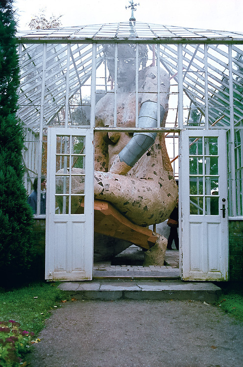 asylum-art:  A Towering Figure Enclosed Within a Glass Greenhouse by Susanne Ussing