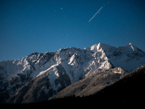 Mt. Currie lit up by the full moon as a plane leaves it’s mark above it