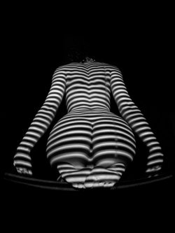 Shadows and lines surround her, outline her,