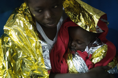 A woman and her baby who were rescued from a wooden boat off the coast of Libya by the Migrant Offsh