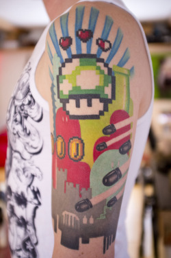 fuckyeahtattoos:  Nintendo sleeve. I’m an old school gamer geek. Guess it shows. This one is about life. Going from evil at the bottom to good at the top. We all want extra life, don’t we? Done by the fantastic Mina @ Hawk and Sparrows in Malmö,