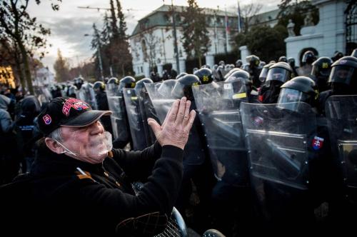 A man gestures in front of anti-riot police during a protest of hundreds of football hooligans and f