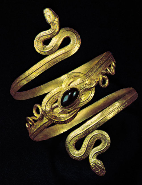 aloneandforsakenbyfateandbyman: Gold spiral bracelet set with a garnet depicting two snakes whose ta