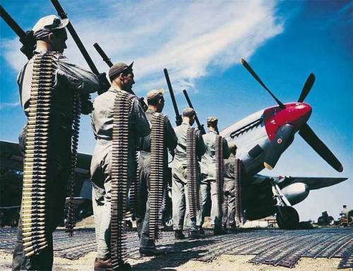 warhistoryonline:American ground crew preparing to arm P-51 Mustang fighter at an airfield with six 