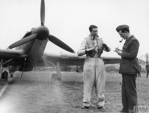 Pilots of &lsquo;B&rsquo; Flight, No. 32 Squadron, relax on the grass at RAFHawkinge in front of a H