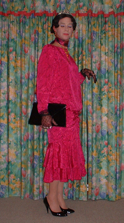 A lovely pink satin dress with flounced skirt. Lacy gloves a black handbag and shoes diamante jewell