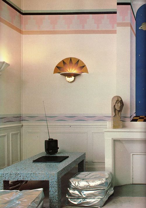 80sdeco:  Aztec accent border, tile parsons table, metallic cushions, 80s deco sconce. 