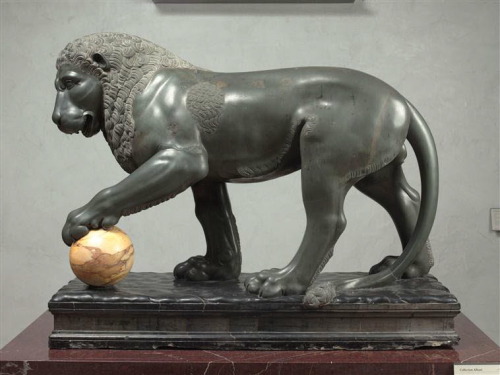 Is there a cat anywhere that can resist a shiny ball?[ID: A sculpture of a lion, with a detailed inc