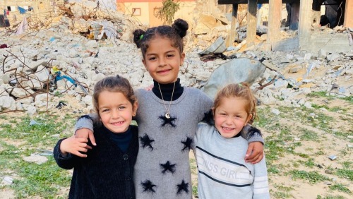 Rafeef, Ayla, and Aylool smile amid the rubble in Rafah
