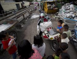 purplevalkyrie:  Japanese businessman Akihiro Tomikawa, 44, wearing a costume of a masked rider character from a Japanese comic, distributes toys to underprivileged children in slum areas in Bangkok. Thailand Thursday, Oct. 3, 2013. Tomikawa makes a trip