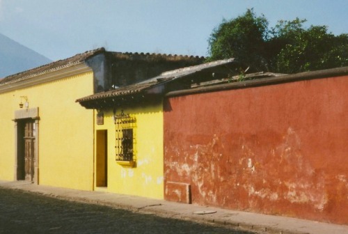 Escena de la calle con dos casas amarillas y un pared rojo, Antigua, Guatemala, 2002.