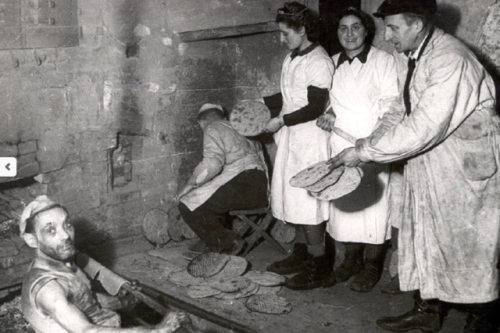 A Passover Seder in the Warsaw Ghetto, PolandJews around a Seder table reading from the Passover Hag