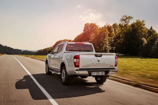 Picape Renault Alaskan na cor prata em movimento na estrada com a traseira em detalhe