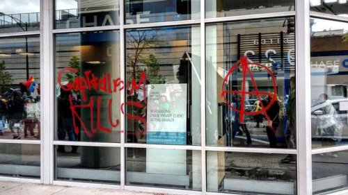 Anarchists in Chicago write ‘Capitalism Kills’ on a bank during the May day 2017 demo.