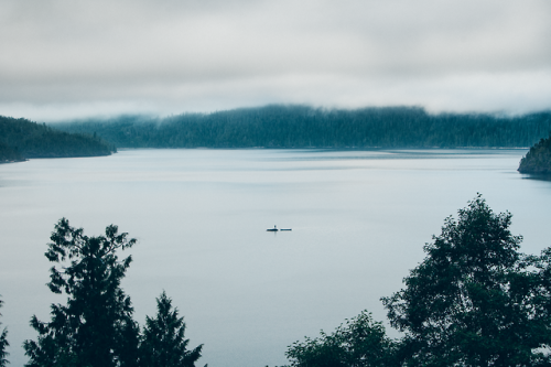 benchandcompass: just a man and his canoe on a rock in a lake. 