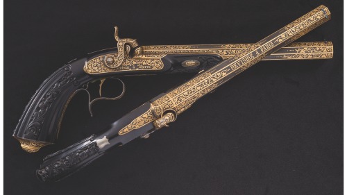 A pair of gold inlaid percussion dueling pistols with carved ebony stocks, crafted by Devisme of Par