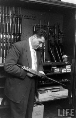 noirbynight:  A Cincinnati plainclothes officer inspecting a submachine gun in the weapons room, 1960.  Photo by Francis Miller for LIFE Magazine. source: LIFE Google Archive