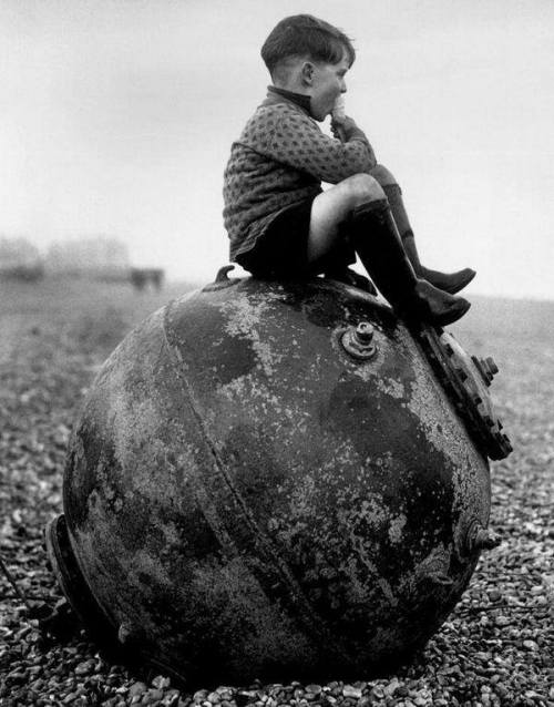 Boy sitting on a sea mine, Kent, England, 1940
