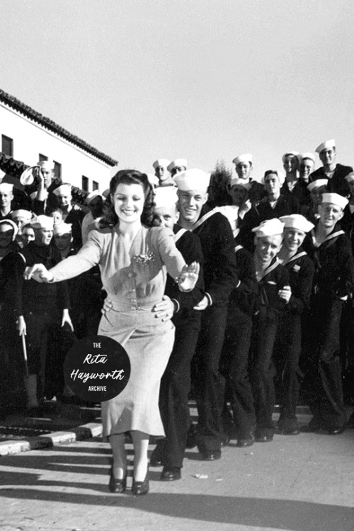 Rita Hayworth leads a conga line of sailors, 1941