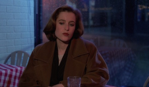 cyberscully:fbi agent dana scully sitting in a diner at night looking beautifully solemn as rain fal