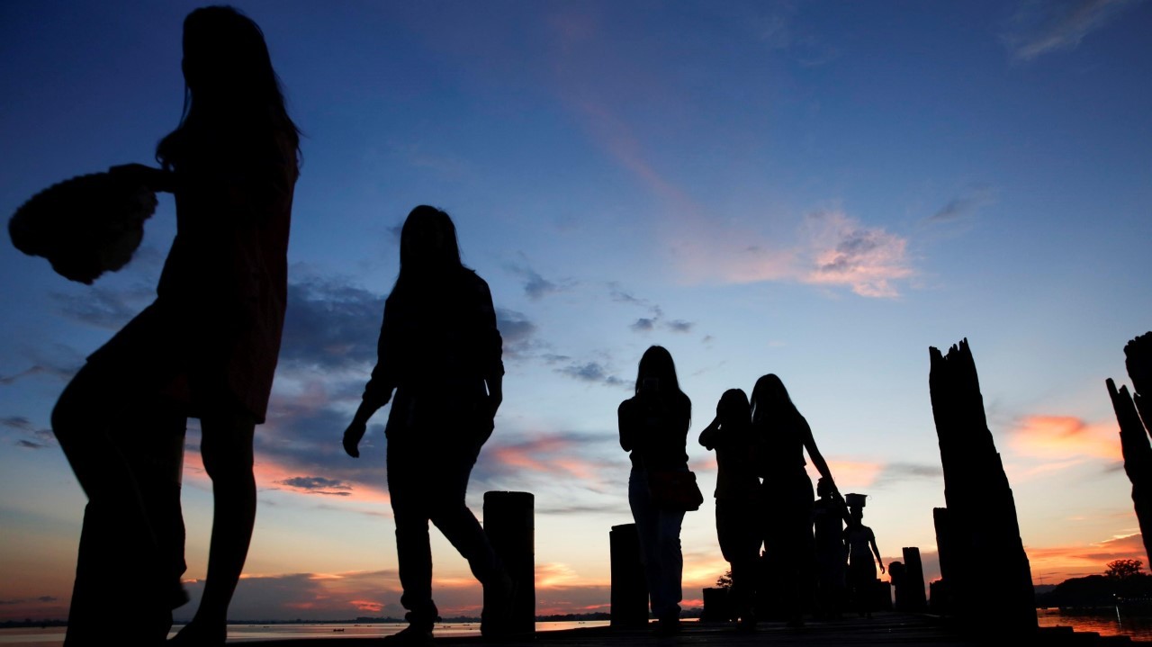 SALTO AL ATARDECER. Los niños de Myanmar saltan al agua mientras la gente disfruta de la puesta de sol en el puente U Pain (U Bein) en Mandalay, Myanmar. La pasarela se extiende 1,2 km sobre el lago Taungthaman conectando sus dos bancos cerca de...