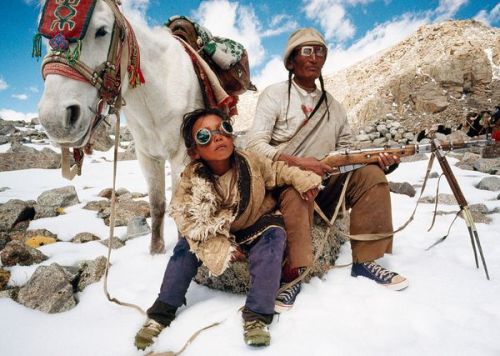 A Tibetan father with son on a pilgrimage to Mount Kailas in China.  Note the old Mosin Nagant bolt 
