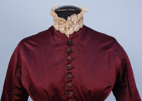 SILK BUSTLE DRESS with BEADED TRIM, c. 1880. 2-piece claret satin and taffeta having fringe, buttons