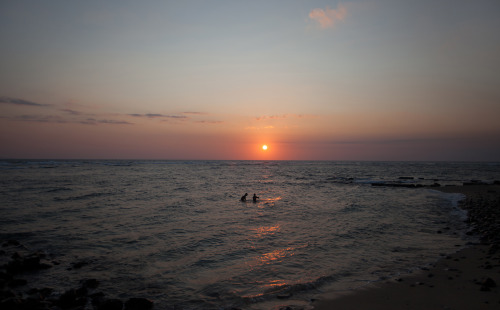 Indonesian boys play in the water at sunset Lombok, Indonesia