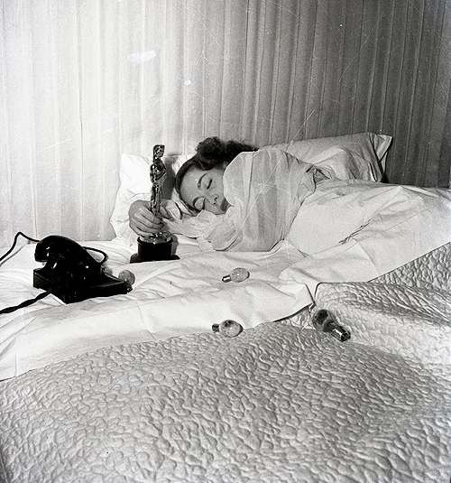 howtowhistle:Joan Crawford in bed clutching the Oscar for winning Best Actress in 1946 for Mildred P