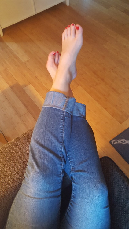 My pretty wifes sexy bare feet hanging off the arm of the couch on her phone.please comment