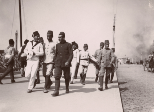 Turkish soldiers and sailors walk along an Istanbul promenade