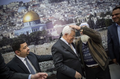 Palestinian Authority President Mahmoud Abbas is blessed by a religious Jewish man while posing for 