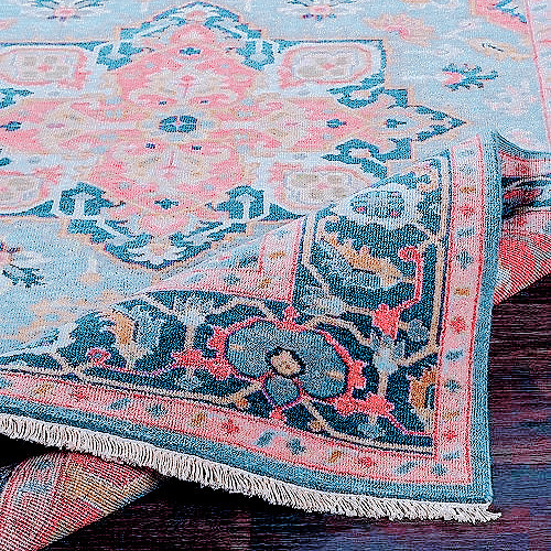 elaborate carpets with geometric designs in various shades of pink and pale blue, corners half folded up.