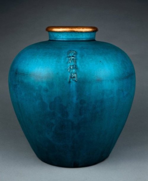 Wine jar with turquoise glaze and copper rim.